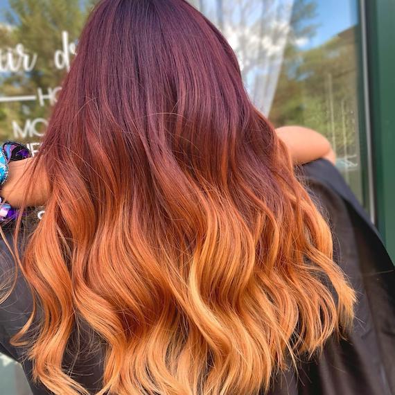 Back of woman’s head with wavy hair and a mahogany to strawberry blonde dip-dye, created using Wella Professionals.