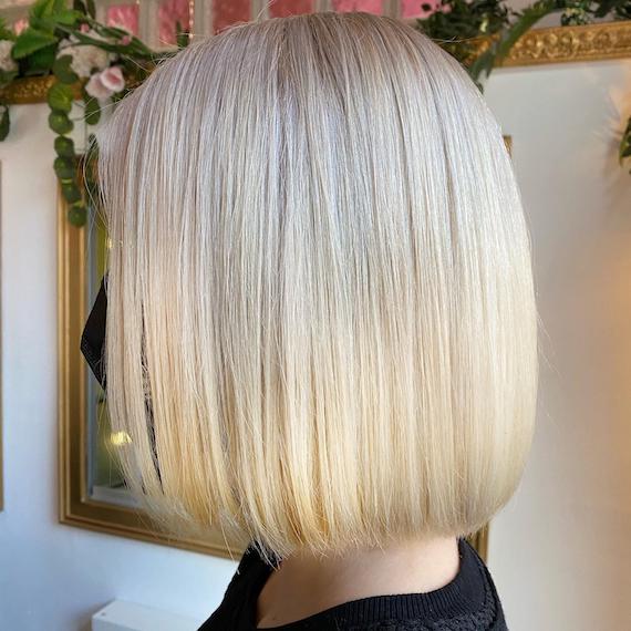 Side profile of woman with vanilla blonde bob, created using Wella Professionals.