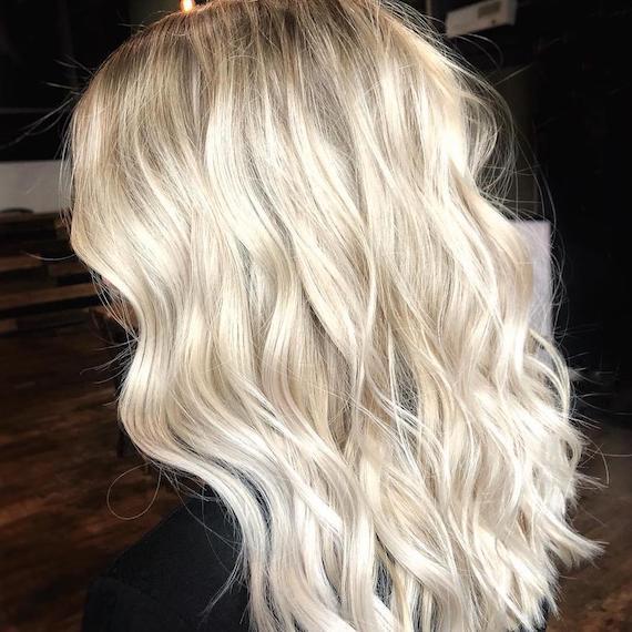 Bright blonde highlights and tousled waves, created using Wella Professionals