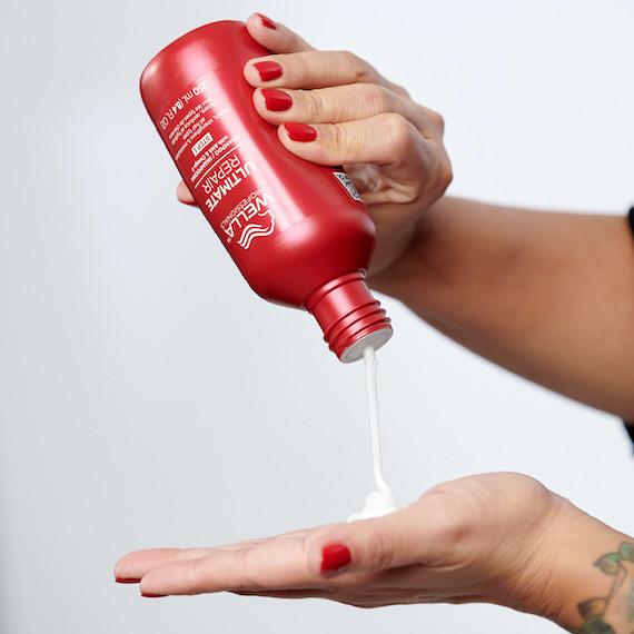 ULTIMATE REPAIR Shampoo poured into the palm of a model’s hand.