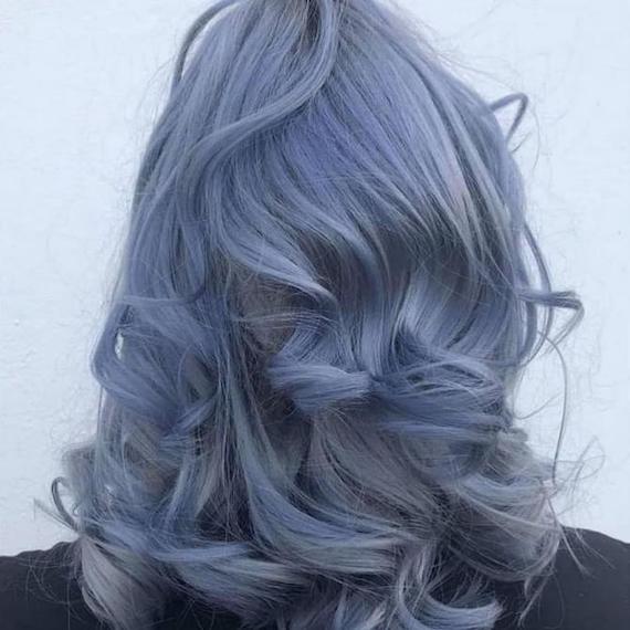 Back of woman’s head with loosely curled, dark blue grey hair, created using Wella Professionals.