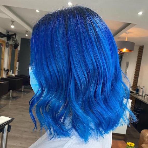 Side profile of woman with bright blue bob haircut, created using Wella Professionals.