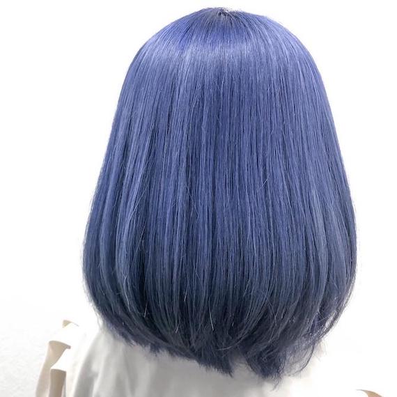 Back of woman’s head with straight, navy blue bob haircut, created using Wella Professionals.