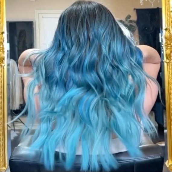 Back of model’s head with long, wavy, bright blue ombre hair.