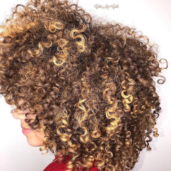 Back of woman’s head with bronde curly hair, created using Wella Professionals.