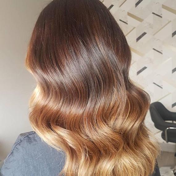 Back of woman’s head with loosely curled, bronde ombre hair, created using Wella Professionals.