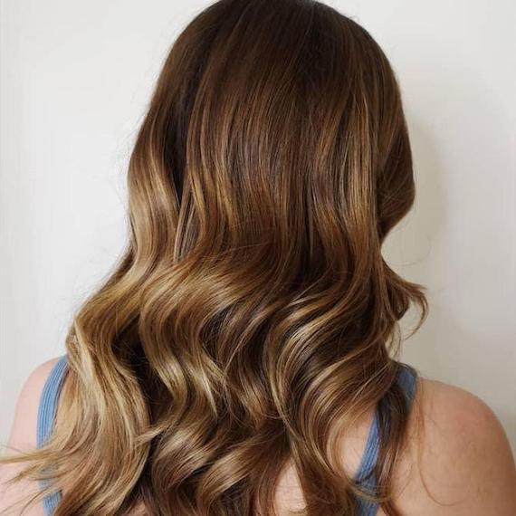 Back of woman’s head with light brown hair and balayage, created using Wella Professionals