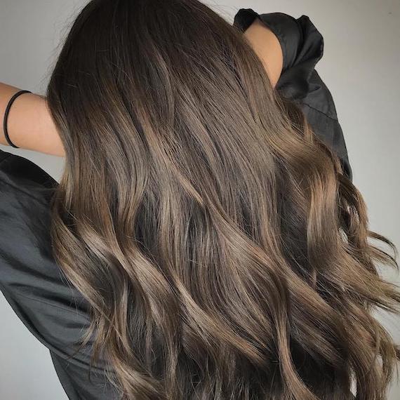 Photo of the back of a woman’s head with long ash brown hair and balayage, created using Wella Professionals.