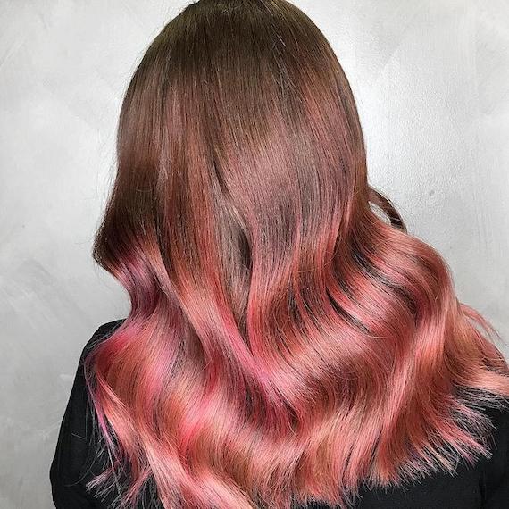 Photo of the back of a woman’s head with long rose brown balayage through hair, created using Wella Professionals.