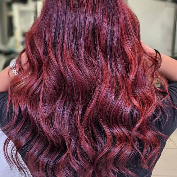 Woman with long burgundy hair with highlights created with Wella Professionals