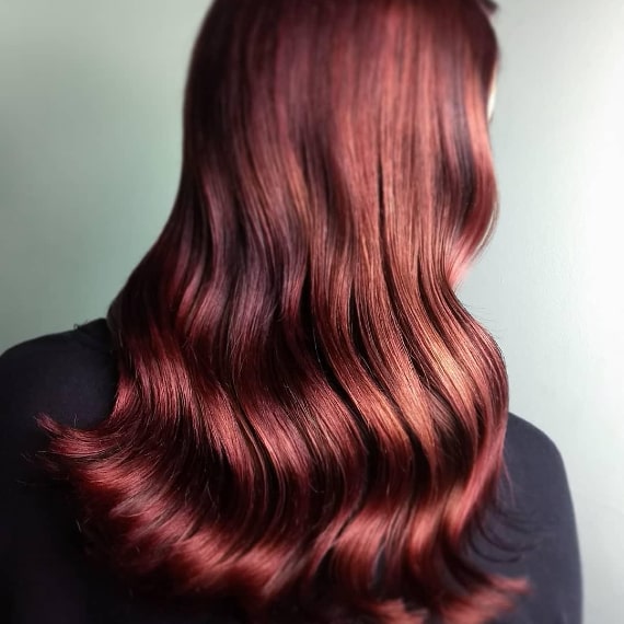 Woman with sleek, burgundy red hair created with Wella Professionals