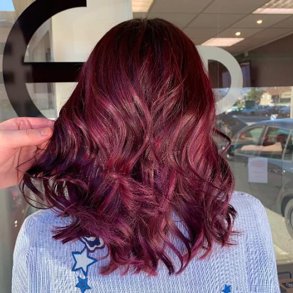 Woman with medium length hair in purple burgundy hair created with Wella Professionals