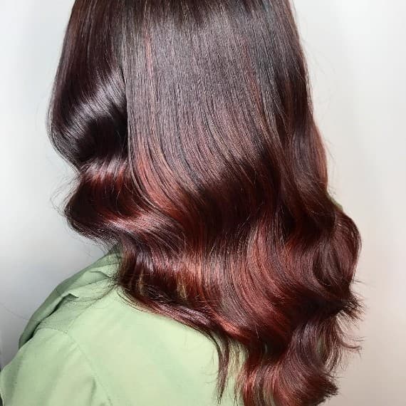 Woman with medium length hair in purple burgundy hair created with Wella Professionals