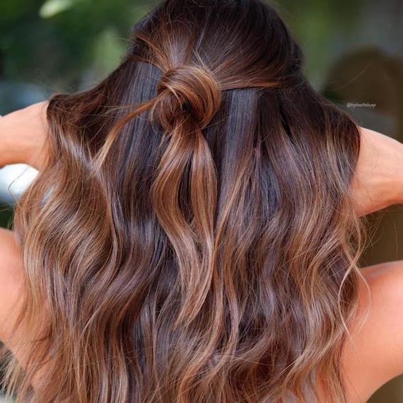 Back of woman’s head with dark brown hair and subtle caramel balayage, created using Wella Professionals.