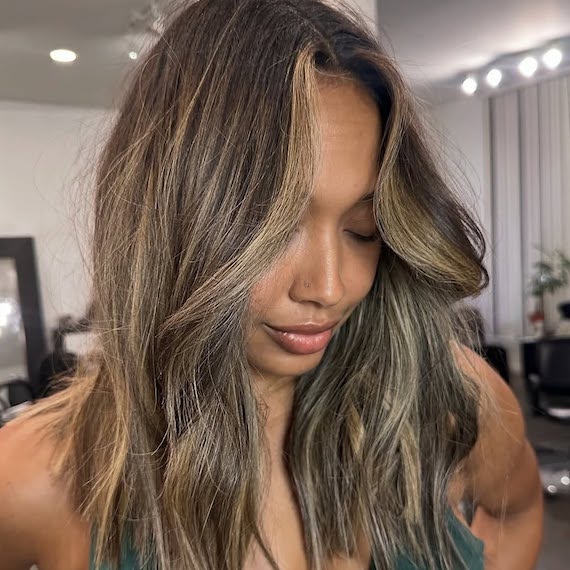 Caramel brown hair with a dark root melt and radiant bronde mid-length highlights.