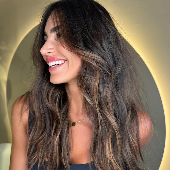 Subtle caramel highlights woven through dark brown hair for a soft, natural glow.