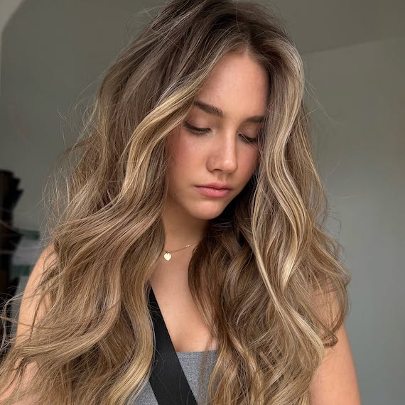 Bronde hair with chunky caramel blonde highlights for a radiant, dimensional look.