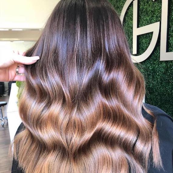 Back of head showing person’s chocolate brown, caramel ombre hair