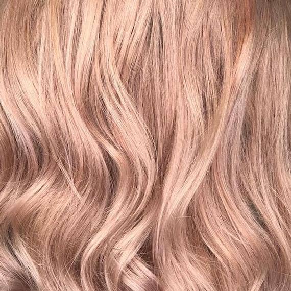 Close-up image of soft blush powdered hair color, showing hair texture styled in loose waves.