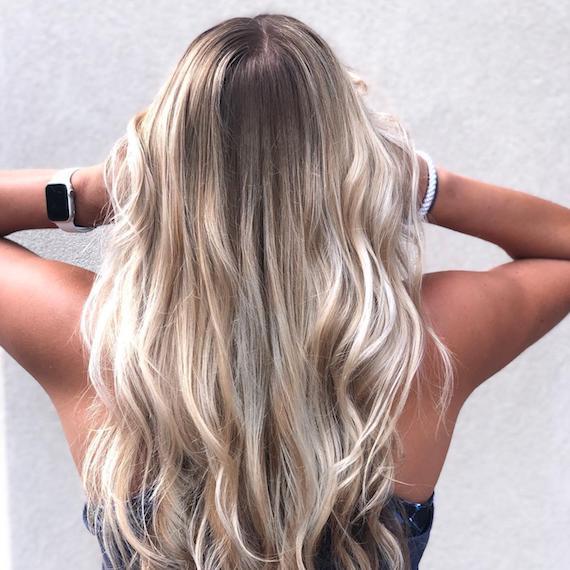 Image of the back of a woman’s head wearing powdered blonde ombre hair color.