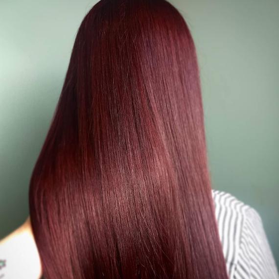 Photo of long, straight, black cherry hair, created using Wella Professionals.