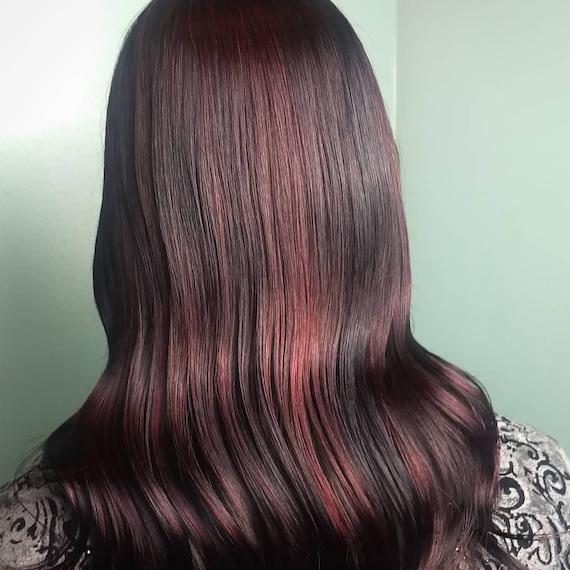 Photo of long, wavy, cherry cola hair, created using Wella Professionals.