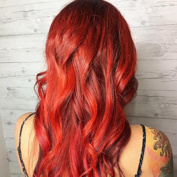 Photo of long, wavy, cherry red hair, created using Wella Professionals.