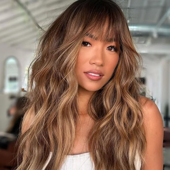 Chocolate brown hair with honey-coloured highlights and sun-kissed vibrancy.