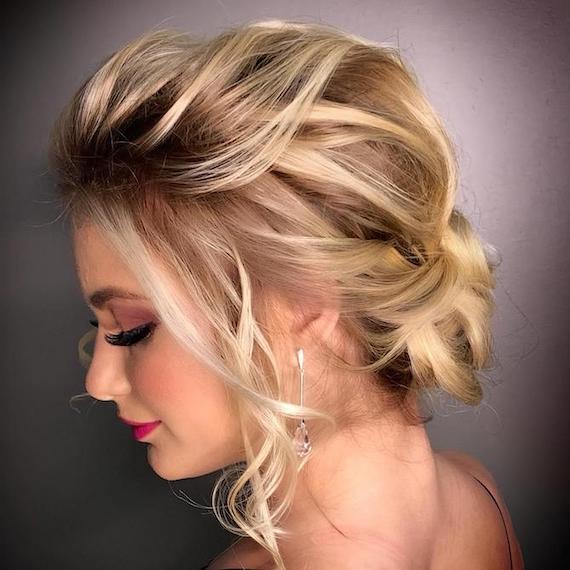 Side profile of woman with blonde hair styled in a low chignon, created using Wella Professionals.