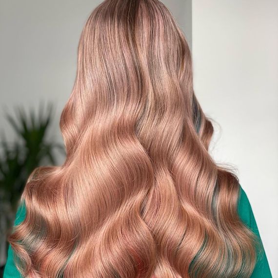 Back of model’s head with long, wavy hair and cinnamon blonde highlights.