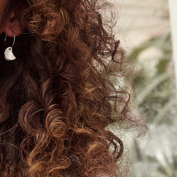 Close-up of model’s dark brown, curly hair.