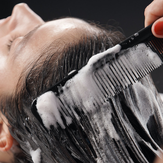 Close-up of model’s hair being shampooed.