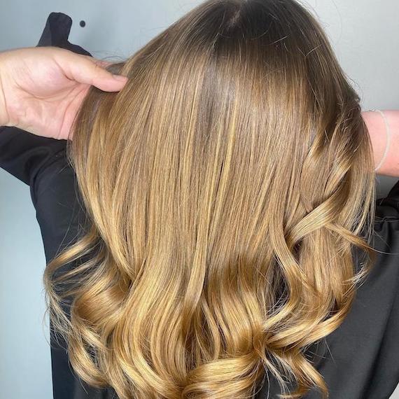 Back of woman’s head with glossy bronde hair, created using Wella Professionals.