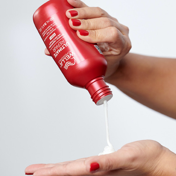 ULTIMATE REPAIR Shampoo is poured into a model’s hand. 
