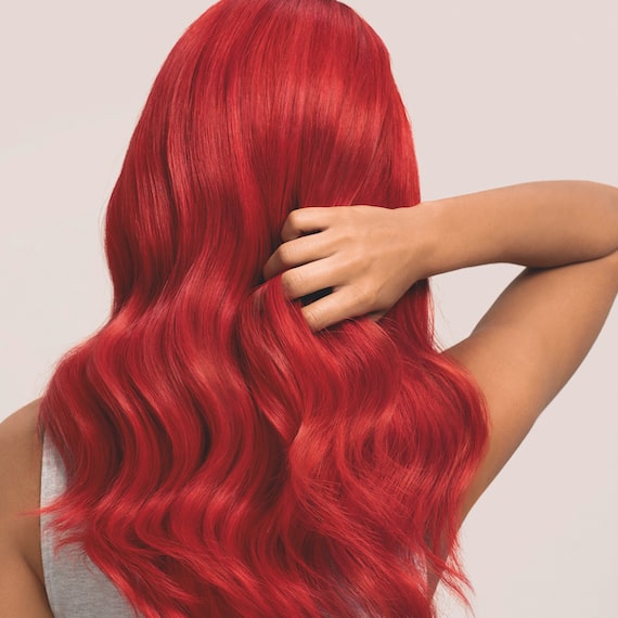 Back of woman’s head with long, wavy, red hair.