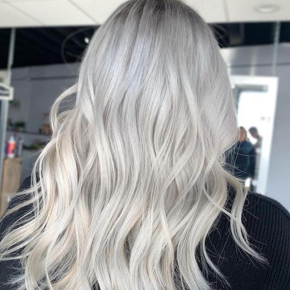 Back of model’s head with long, wavy, silver hair.