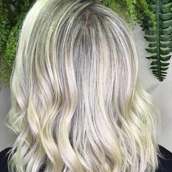 Back of woman’s head with wavy platinum blonde hair, created using Wella Professionals.