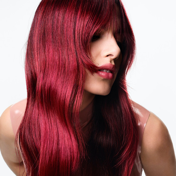 Model with long hair featuring a glossy, cherry red Color Touch Melt.