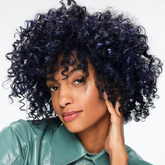 Model with curly, black hair and melted tones of deep blue.