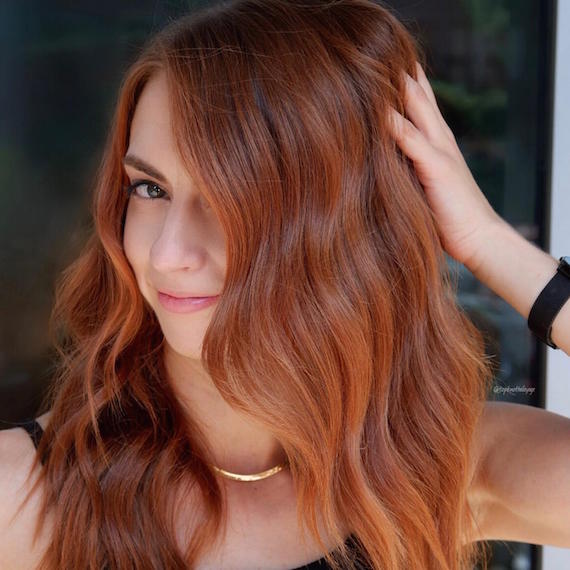 Photo of woman with mid-length, wavy, auburn copper hair color, created using Wella Professionals.