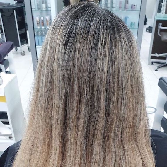 Before image of highlighted hair with gray regrowth.