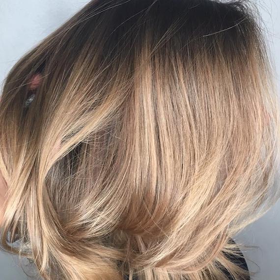 Image of the side of a woman’s head with dark blonde hair and dark roots, styled in a softly tousled bob. Look created by Wella Professionals.