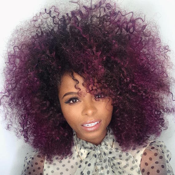 Woman with curly, dark purple hair, created using Wella Professionals.