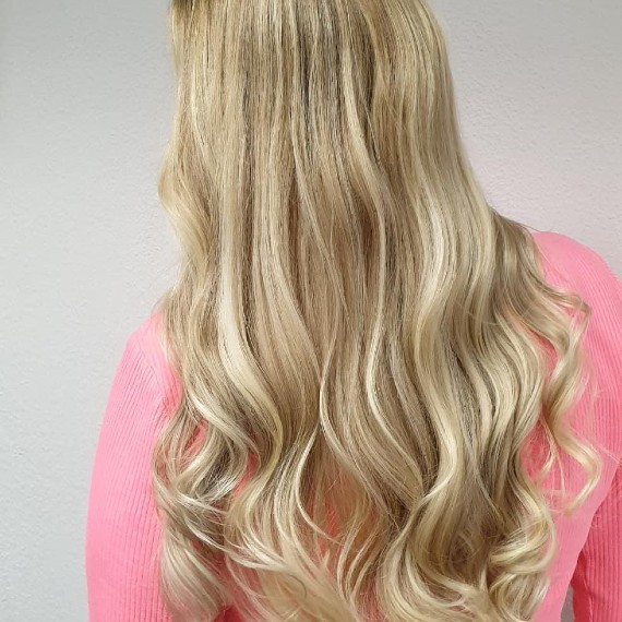 Frau mit langem Haar in sandblondem Balayage und hellen Strähnchen