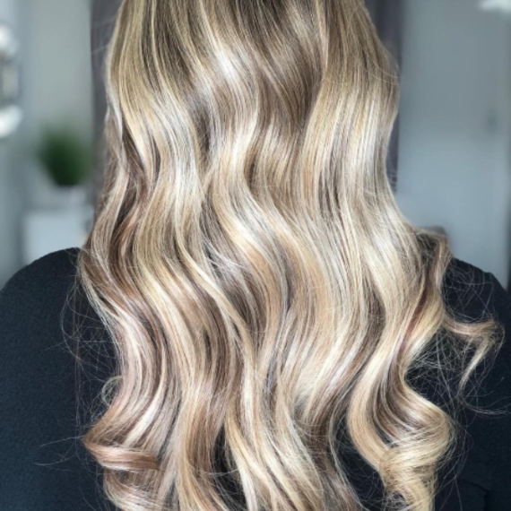 back of woman’s head with long dark blonde hair and blonde highlights