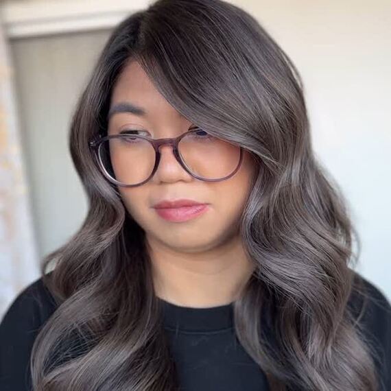 Model with long, dark brown hair featuring smoky silver balayage.