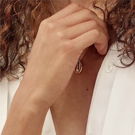 Close-up of brown, curly hair falling past a model’s shoulders.