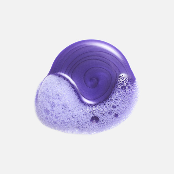 Drop of purple shampoo on a white background.