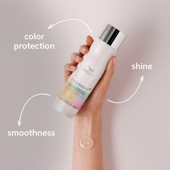 Hand holds up a bottle of ColorMotion+ Color Protection Shampoo, which gives hair shine, smoothness and shade protection.