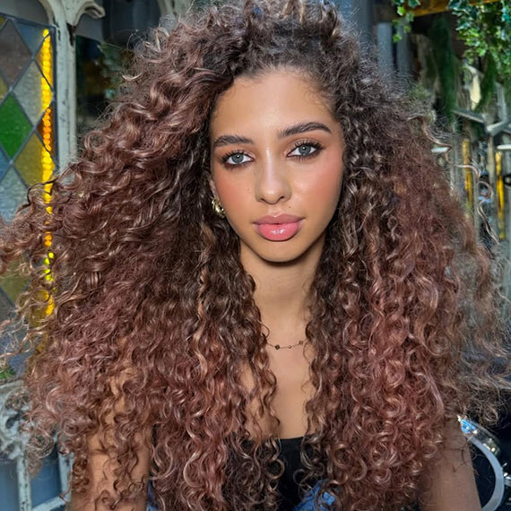 Model with glossy, rose brown, curly hair.